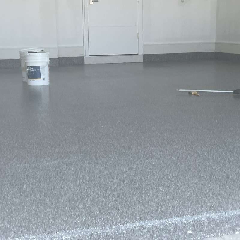 Epoxy-coated floor with paint bucket and roller handle.