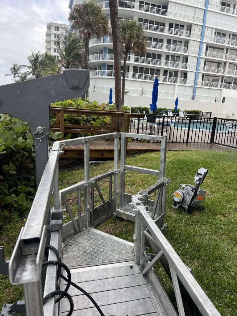 Aluminum lift near poolside and apartment building.