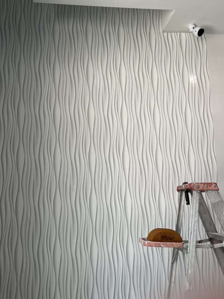 Wavy textured wall with a ladder in front.