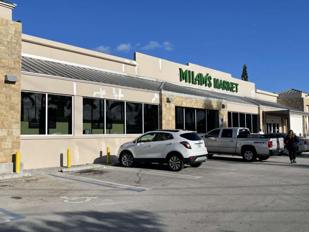 Milam's Market storefront with parked cars.