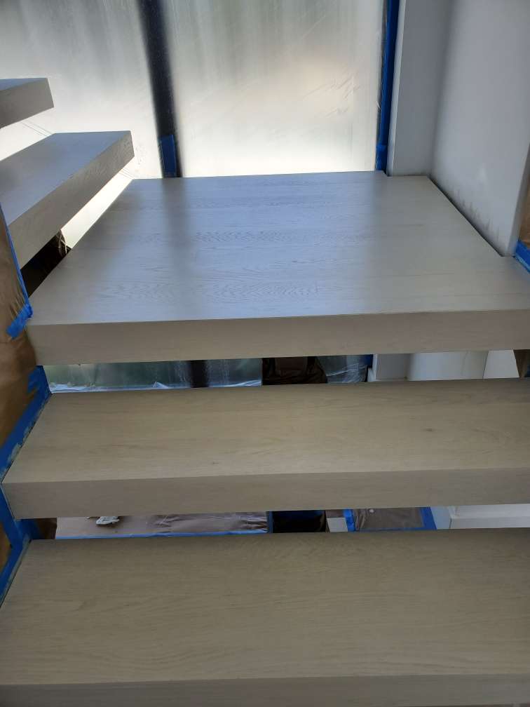 Painted wooden stairs with protective tape.